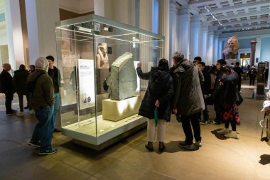 Londra, İngiltere - 27 Ocak 2025: Turistler, antik Mısır hiyerogliflerinin sırlarını açığa çıkaran bir eser olan İngiliz Müzesi 'nde sergilenen ikonik Rosetta Taşı' na hayran kaldılar.