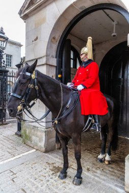 LONDON, İngiltere - 29 Ocak 2025: Tören üniformalı atlı bir Kraliyet Muhafızı, tarihi bir yer ve Londra 'daki Süvari Birliği karargahı olan Atlı Muhafızlar' ın girişinde görev yapıyor.