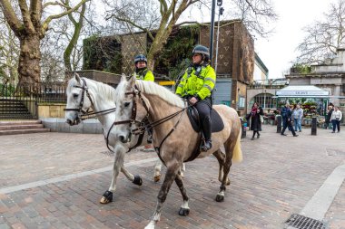 LONDON, İngiltere - 29 Ocak 2025: Londra Embankment İstasyonu yakınlarındaki sokaklarda devriye gezen iki atlı polis memuru. Şehirde güvenlik ve kamu güvenliğini sağlamak için ortak bir görüş.