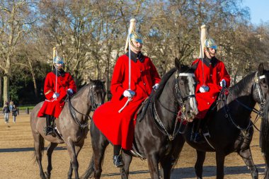 LONDON, İngiltere - 30 Ocak 2025: Kırmızı tören üniformaları ve altın miğferler içinde süvari birlikleri İngiliz geleneği olan Atlı Muhafız Yürüyüşü 'nde Kral Can Kurtarma Yürüyüşü sırasında formasyon sürerler