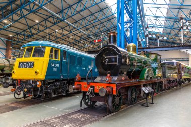 YORK, İngiltere - 6 Şubat 2025: D sınıfı buharlı lokomotifin yan yana görüntüsü No. 737 (1901) ve British Rail Class 84 elektrikli lokomotif No. York Demiryolu Müzesi 'nde 84 001.
