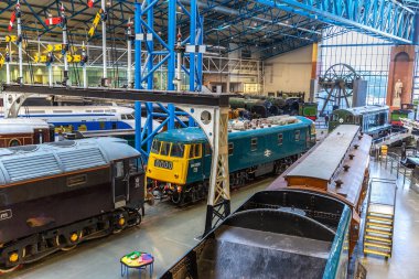 YORK, İngiltere - 6 Şubat 2025: Antika buhar lokomotiflerinin yer aldığı İngiltere, York 'taki Demiryolu Müzesi' nin iç görünümü. Salonda demiryolu mirası klasik sergiler ve endüstriyel tasarımlarla ön plana çıkıyor.