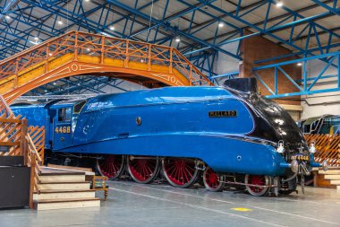 YORK, İngiltere - 6 Şubat 2025: Iconic Mallard buharlı lokomotifi (Hayır. 4468), dünya hız rekoru sahibi, canlı mavi dizayn ve çarpıcı kırmızı tekerleklerle York 'taki Demiryolu Müzesi' nde sergilenmektedir.