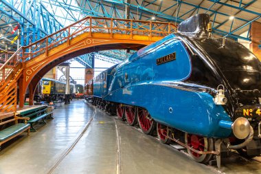 YORK, İngiltere - 6 Şubat 2025: Iconic Mallard buharlı lokomotifi (Hayır. 4468), dünya hız rekoru sahibi, canlı mavi dizayn ve çarpıcı kırmızı tekerleklerle York 'taki Demiryolu Müzesi' nde sergilenmektedir.