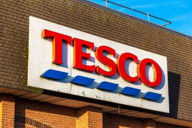 BRIDLINGTON, İngiltere - 27 Şubat 2025: Bridlington, İngiltere 'deki Tesco Superstore tabelasına yakın çekim. Bu İngiliz süpermarket zinciri yerel alışverişçiler için bakkaliye, ev eşyaları ve temel ihtiyaçlar sunuyor.