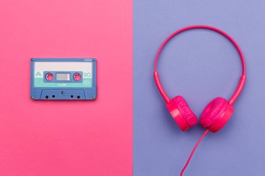 Pembe arka planda mavi ses kaseti ve menekşe arka planda pembe kulaklık. Analog ses müzik kavramı