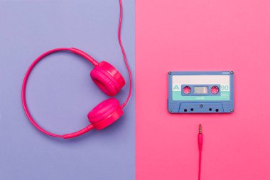 Pembe arka planda mavi ses kaseti ve menekşe arka planda pembe kulaklık. Analog ses müzik kavramı