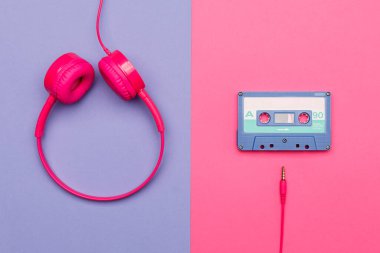 Pembe arka planda mavi ses kaseti ve menekşe arka planda pembe kulaklık. Analog ses müzik kavramı