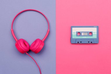 Pembe arka planda mavi ses kaseti ve menekşe arka planda pembe kulaklık. Analog ses müzik kavramı