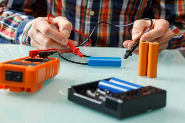 マルチメータでバッテリ電圧を測定する電気技師 ホームマスターとポータブル電源効率が一致 — ストック写真