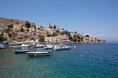 SYMI, GREECE - September 6,2015: View of a coastline street and fishing boats moored in Yialos harbour on Symi island,Greece