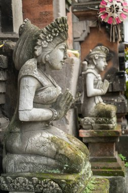 Stone statue with hands in a praying atthe temple' entrance on Bali, Indonesia. Spiritual cullture symbols concept