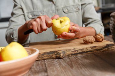 İnsan eli, ahşap bir arka tarafından bıçakla mutfakta elma soyuyordu. Sağlıklı gıda ve veganizm kavramı