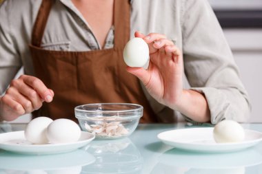 Dişi eller kabuksuz yumurta tutuyor. Haşlanmış yumurta hazırlama ve beslenme konsepti