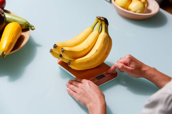 Закройте руки, кладя ветку бананов на вес.Здоровый образ жизни и концепция питания