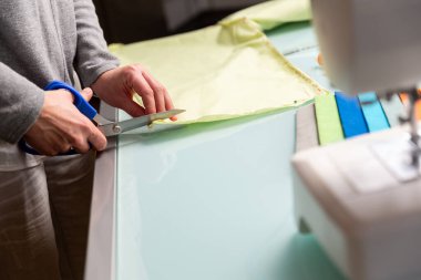 Terzi terzi makasıyla naneli kumaş kesiyor. İşçilik konsepti 