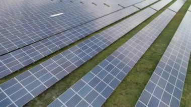 Tarlalardaki güneş panellerinin hava manzarası görüntüleri. Yenilenebilir elektrik enerjisi ve çevre koruma kavramı 