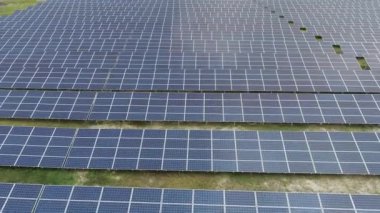 Tarlalardaki güneş panellerinin hava manzarası görüntüleri. Yenilenebilir elektrik enerjisi ve çevre koruma kavramı 