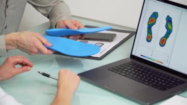 Özel yapım bir klinikte, dizüstü bilgisayardaki test fotoğrafını kullanarak özel yapım özel dikey tabanlı erkek hastaya danışıyorum. Ayak dinlendirme ilacı konsepti