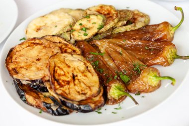 Izgara sebze, patlıcan, yeşil biber ve beyaz tabakta servis edilen kabak. Görüntüyü kapat 