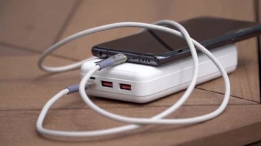 Beyaz taşınabilir enerji bankasının şarj olan cep telefonunun yavaş çekim görüntülerini kapat. Güç depolama kavramı