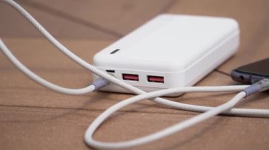 Beyaz taşınabilir enerji bankasının şarj olan cep telefonunun yavaş çekim görüntülerini kapat. Güç depolama kavramı