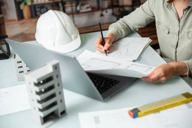 Açık bir uzay ofisinin teknik proje taslağı üzerinde çalışan bir mimar. Gayrimenkul tasarımı ve geliştirme kavramı