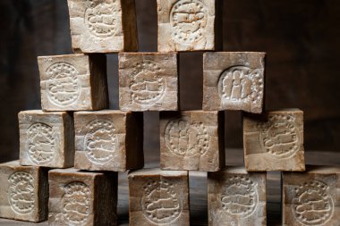 Eski ve kuru geleneksel aleppo çubuk piramidi kahverengi ahşap arka planda organik defne sabunu. 