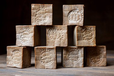 Eski ve kuru geleneksel aleppo çubuk piramidi kahverengi ahşap arka planda organik defne sabunu. 