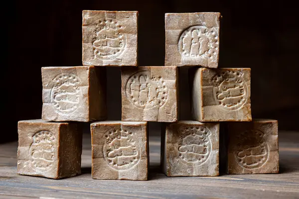 Eski ve kuru geleneksel aleppo çubuk piramidi kahverengi ahşap arka planda organik defne sabunu. 