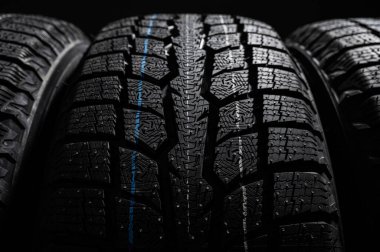 Bir yolcu arabası için bir yığın kış lastiği, yeni temiz kauçuk depolama