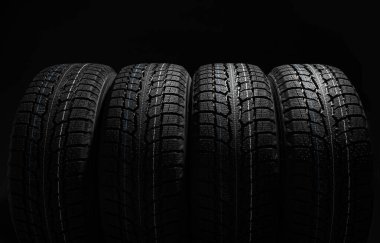 Stack of tires on black backgroun clipart