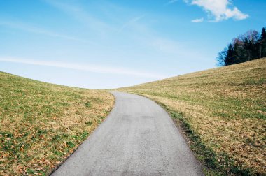 Yol baharda Alpler 'in dağlarında asfaltlanır, rota dağlarda çayırların arasındadır.