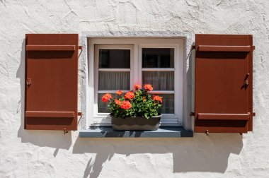 Avrupa 'nın eski kentinde, pencere eşiğinde bir sepet içinde eski pencere ve çiçekler.