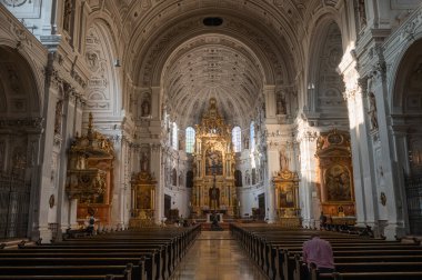 Münih 'teki Gotik katedralin içinde yüksek kubbeli tavanlar, sütunlar ve vitray pencereler var. Tipik ortaçağ Gotik mimari elementlerini kaburgalı atlama ve sivri kemerlerle gösterir.