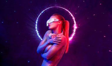 Gözlüklü ve kulaklıklı neon ışıklı kız DJ. Yüzünde ve vücudunda menekşe rengi boyalı güzel bir kadın. Kulüp partisinde seksi TDJ portresi