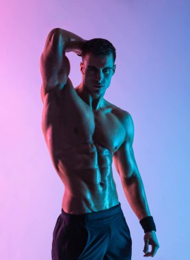 Yakın çekim vücut fotoğrafı. Pembe arka planda izole edilmiş erkek sporcu. Spor salonu tüm vücut egzersizi. Spor salonundaki kaslı erkek sporcu antrenman yapıyor. Spor eğitmeni antrenman yapıyor. Fitness motivasyonu