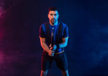 Raketli Padel tenisçi. Sahada raketli, neon renkli bir erkek sporcu. Spor konsepti. Bir spor uygulaması ya da bahis sitesi tasarımı için yüksek kaliteli bir fotoğraf indir