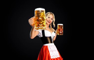 Büyük meme siyah dirndl ile koyu arka plan üzerinde bira bardağı Isolated holding beyaz bluz giyen genç seksi sarışın varoluş portresi