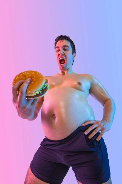 非常に太った男はクリームで自分自身をジョージします 肥満と摂食障害について ソーシャルネットワークにおける栄養士とフィットネス広告のコンセプト — ストック写真