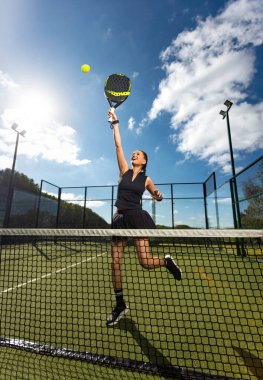 Raketli Padel tenisçi. Sahada raketi olan kız sporcu. Spor konsepti. Bir spor uygulaması ya da web sitesi tasarımı için yüksek kaliteli bir fotoğraf indir