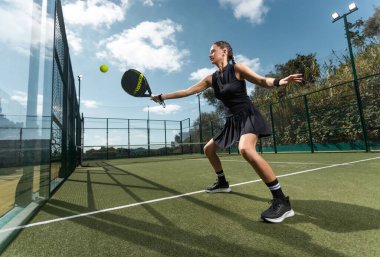 Raketli Padel tenisçi. Sahada raketi olan kız sporcu. Spor konsepti. Bir spor uygulaması ya da web sitesi tasarımı için yüksek kaliteli bir fotoğraf indir
