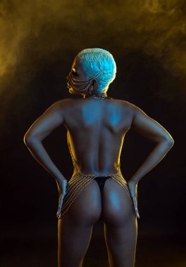 Gözlüklü ve kulaklıklı neon ışıklı kız DJ. Yüzünde ve vücudunda menekşe rengi boya olan güzel bir kadın. Kulüp partisinde seksi TDJ portresi