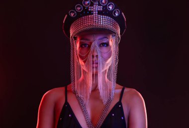 Gözlüklü ve kulaklıklı neon ışıklı kız DJ. Yüzünde ve vücudunda menekşe rengi boyalı güzel bir kadın. Kulüp partisinde seksi TDJ portresi