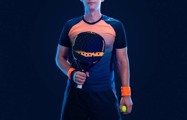 Raketli Padel tenisçi. Sahada raketli, neon renkli bir erkek sporcu. Spor konsepti. Bir spor uygulaması ya da bahis sitesi tasarımı için yüksek kaliteli bir fotoğraf indir
