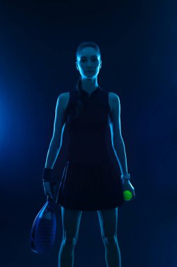Raketli Padel tenisçi. Sahada raketi neon renkli genç bir sporcu kız. Spor konsepti. Bir spor uygulaması ya da bahis sitesi tasarımı için yüksek kaliteli bir fotoğraf indir