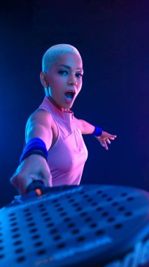 Raketli Padel tenisçi. Sahada raketi neon renkli genç bir sporcu kız. Spor konsepti. Bir spor uygulaması ya da bahis sitesi tasarımı için yüksek kaliteli bir fotoğraf indir