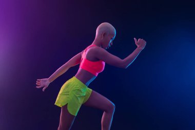 Spor, fitness ve spor motivasyon giymiş siyah arka plan üzerinde çalışan bir güçlü atletik, kadın sprinter. Runner kavramı kopya alanı ile