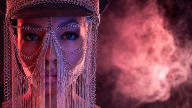 Gözlüklü ve kulaklıklı neon ışıklı kız DJ. Yüzünde ve vücudunda menekşe rengi boya olan güzel bir kadın. Kulüp partisinde seksi TDJ portresi