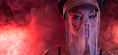 Gözlüklü ve kulaklıklı neon ışıklı kız DJ. Yüzünde ve vücudunda menekşe rengi boya olan güzel bir kadın. Kulüp partisinde seksi TDJ portresi